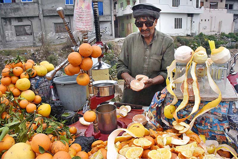 A vendor extracting orange juice for customers at his roadside setup
