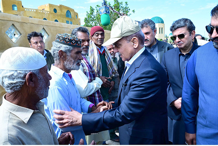 Prime Minister Muhammad Shehbaz Sharif consoling the affectees of torrential rains at a relief camp.