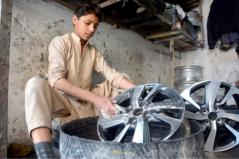 Youngster busy in washing alloy rims before selling at his workplace near Shoba Bazar.