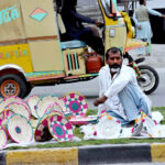 A vendor displayed hand-made plates and baskets at roadside green belt to sell for livelihood