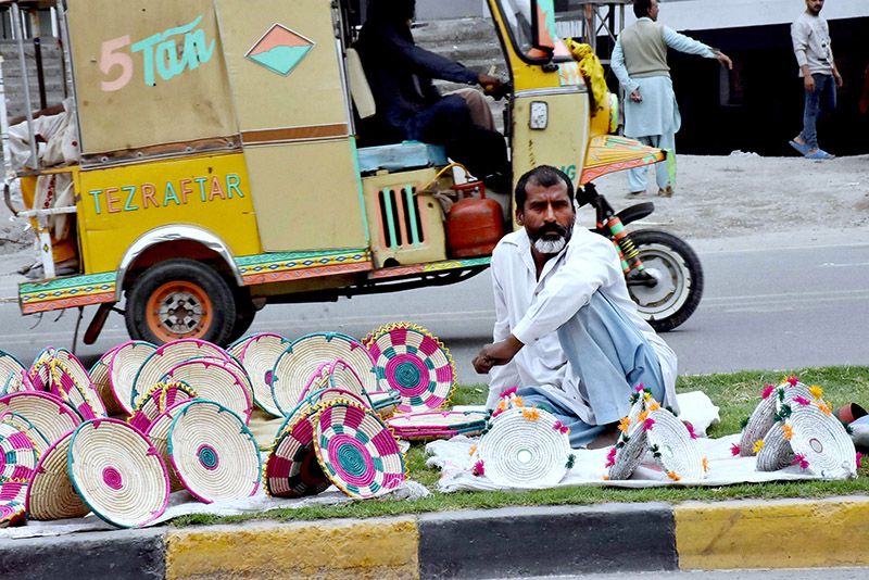 A vendor displayed hand-made plates and baskets at roadside green belt to sell for livelihood