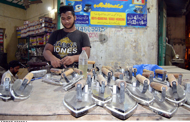 Worker is busy putting the finishing touches on a gas iron at his workplace.