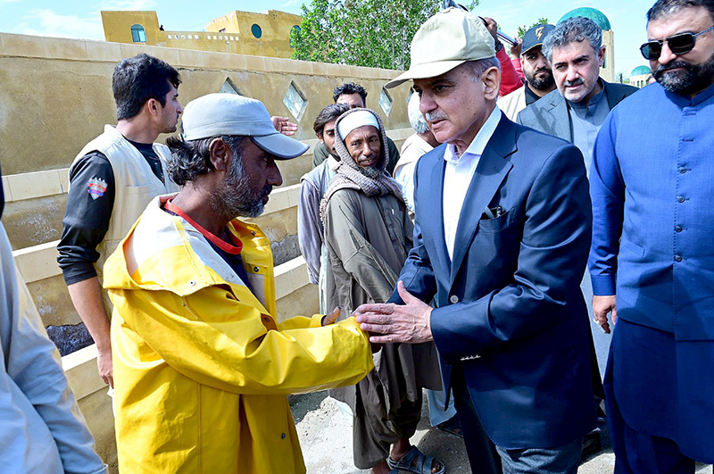 Prime Minister Muhammad Shehbaz Sharif consoling the affectees of torrential rains at a relief camp