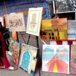 A woman looks to the displayed painting and calligraphy during an exhibition in collaboration with The Fortnite School System at Food Street, Fort Road.