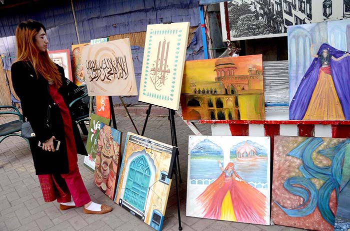 A woman looks to the displayed painting and calligraphy during an exhibition in collaboration with The Fortnite School System at Food Street, Fort Road.