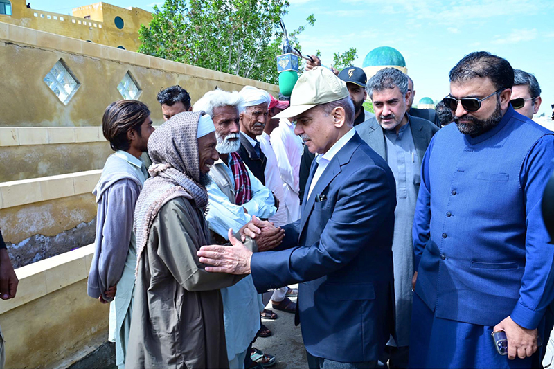 Prime Minister Muhammad Shehbaz Sharif consoling the affectees of torrential rains at a relief camp