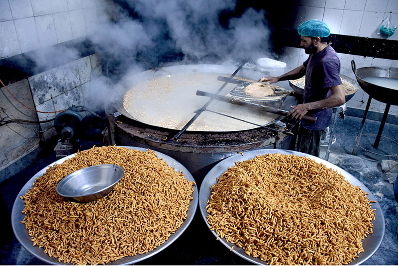 A worker busy in frying traditional food item Pakoriyaa mostly used in Dahi Bhalle during Iftar in the holy fasting month of Ramzan