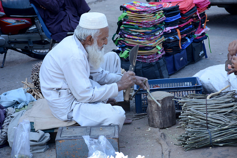 A vendor makes Maswak (Tooth cleaning stick) at the Clock Tower Chowk.