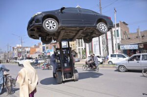 A motorcyclist is carrying a solar panel on the busy City Road