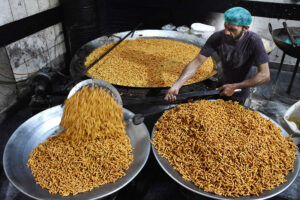 A worker busy in frying traditional food item Pakoriyaa mostly used in Dahi Bhalle during Iftar in the holy fasting month of Ramzan