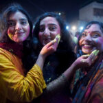 Hindu women devotees daubed in coloured powder take part in Holi celebrations at the Swaminarayan Temple.
