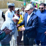 Prime Minister Muhammad Shehbaz Sharif consoling the affectees of torrential rains at a relief camp