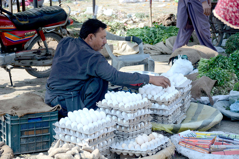 A vendor displaying eggs to attract the customers at vegetable market