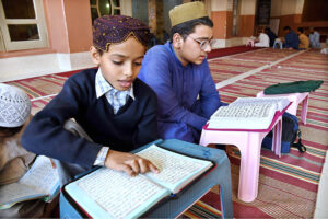 Madrasa students reciting Holy Quran in a mosque during Holy Fasting Month of Ramzan