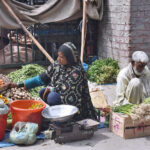 A woman selling vegetables and pickles at road side to earn for livelihood