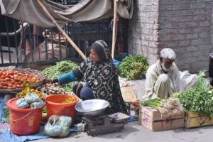 A woman selling vegetables and pickles at road side to earn for livelihood