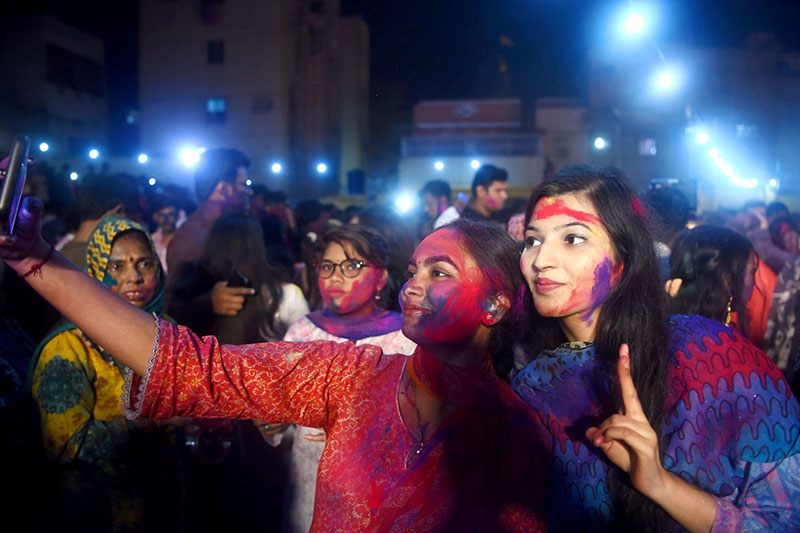 Hindu women devotees daubed in coloured powder take part in Holi celebrations at the Swaminarayan Temple.