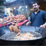 A vendor roasts a chicken for customers during the Holy Fasting Month of Ramzanul Mubarak