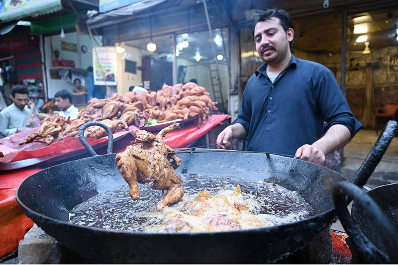 A vendor roasts a chicken for customers during the Holy Fasting Month of Ramzanul Mubarak