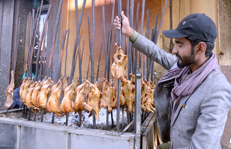 A vendor roasts Chicken Sajji at Prince Road.