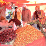 People purchasing Dates from a vendor at Meezan Chowk