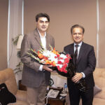 Coordinator to Prime Minister for National Health Services, Regulations and Coordination, Dr. Malik Mukhtar Ahmed Bharath, is being presented with a bouquet of flowers by Federal Secretary Iftikhar Ali Shallwani upon his arrival at the Ministry