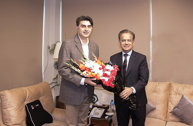 Coordinator to Prime Minister for National Health Services, Regulations and Coordination, Dr. Malik Mukhtar Ahmed Bharath, is being presented with a bouquet of flowers by Federal Secretary Iftikhar Ali Shallwani upon his arrival at the Ministry