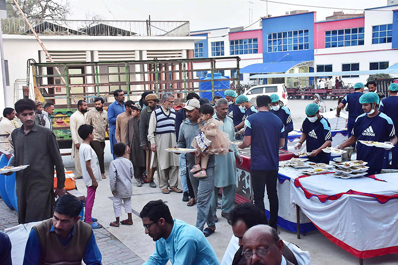 Volunteers distributing food for Iftar among fasting people at Allama Iqbal memorial teaching hospital