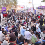 Volunteers distributing food among fasting people during an Iftar at Numaish Chowrangi