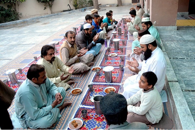 People offering Duaa before breaking their fast during the first Iftar of Ramadan at a local mosque