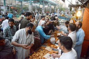 Volunteers distributing food among fasting people during an Iftar at Numaish Chowrangi