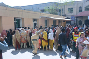 A large number of people standing outside Allied Hospital (II) to make get slip.