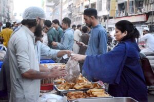 Volunteers distributing food among fasting people during an Iftar at Numaish Chowrangi