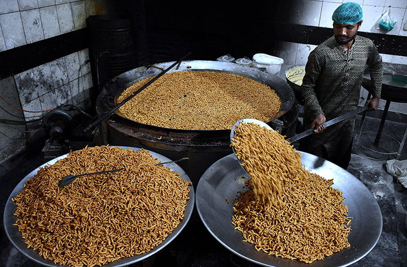A worker busy in frying traditional food Pakoriyaa mostly used in Dahi Bhalle during the holy fasting month of Ramzan