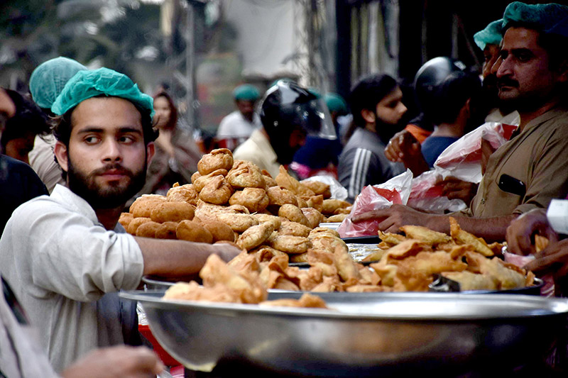 A worker busy in frying traditional food Pakoriyaa mostly used in Dahi Bhalle during the holy fasting month of Ramzan