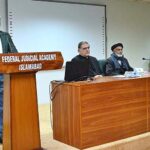 A course participant expressing his views on behalf of trainees in the certificate awarding ceremony at the Federal Judicial Academy. DG of the Academy, Hayat Ali Shah and Baba Ali Rehman, a retired Naib Qasid of Lahore High Court, who was the Guest of Honour sitting on the stage