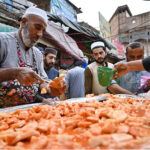 Vendor selling Kachalu Pera to the customers during first Ramzan ul Mubarak at Hashtnagri area