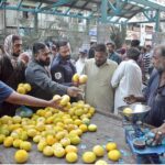 People buying fruits from a vendor on 2nd day of Ramazan at Saddar