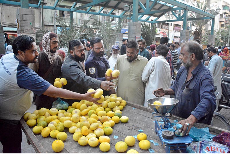 People buying fruits from a vendor on 2nd day of Ramazan at Saddar