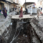 A view of the open manhole on the side of main Hashtnagri Chowk while people using temporary wooden bridge to cross the dig may cause any misshape needs the attention of concert authorities