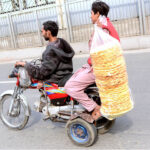 A special person driving a tricycle bike selling edible stuff while shuttling on the road to earn livelihood