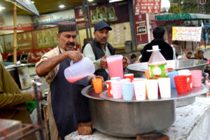 Volunteers distributing food among fasting people during an Iftar at Ferozepur Road.