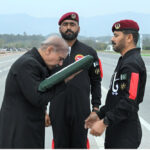 As a gesture of respect, Prime Minister Muhammad Shehbaz Sharif caress Pakistan flag presented to him by Major General Adil Rehmani of Special Services Group of Pak Army during Pakistan Day Parade 2024