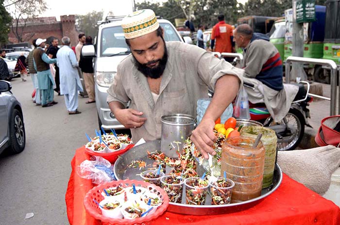 A vendor prepares Alochana Chaat at his roadside setup to attract customers.