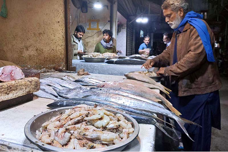 Vendor displaying fishes as demand increases at Fish Market