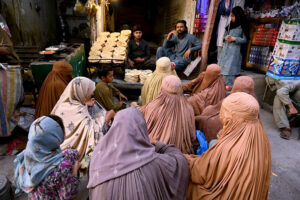 Women waiting in front of a Tandoor for free distribution of bread loaf by philanthropists at Ghanta Ghar Chowk