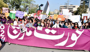 Participants displaying placards as a large women from all walks of life participating in a rally (Aurat March) to mark International Women’s Day