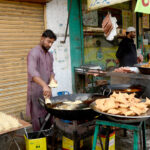 A vendor busy in preparing traditional fritter food Samosa outside his shop during Holy Fasting Month of Ramzan
