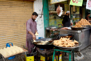 A vendor busy in preparing traditional fritter food Samosa outside his shop during Holy Fasting Month of Ramzan