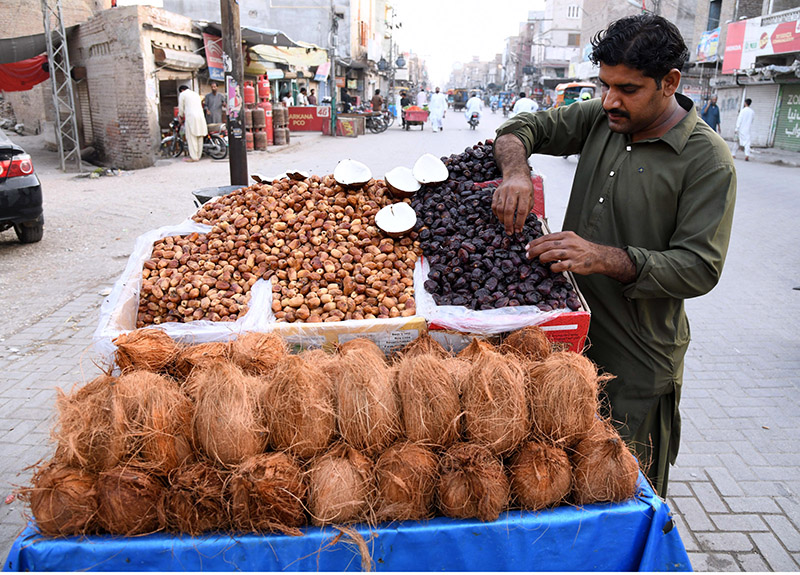 A vendor displays Dates and Coconuts to attract the customers during Holy Fasting Month of Ramzan